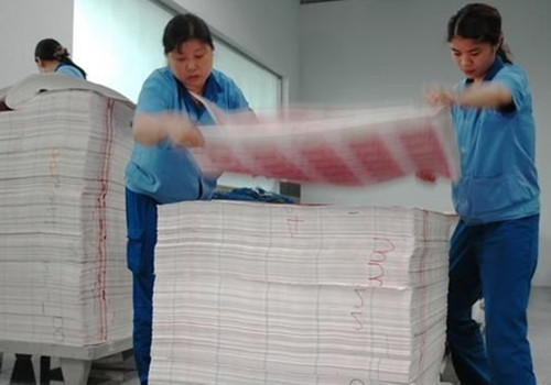 印钞工人把印制成的人民币堆起来