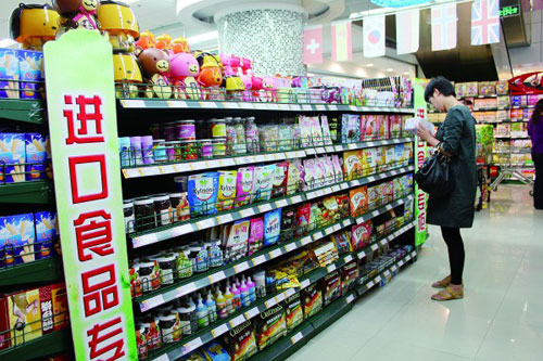 振华购物超市进口食品专柜内，一市民正在看食品外包装上备注的中文标签。  